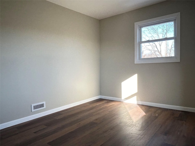 unfurnished room with dark hardwood / wood-style flooring