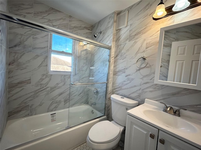 full bathroom with tile walls, enclosed tub / shower combo, vanity, and toilet