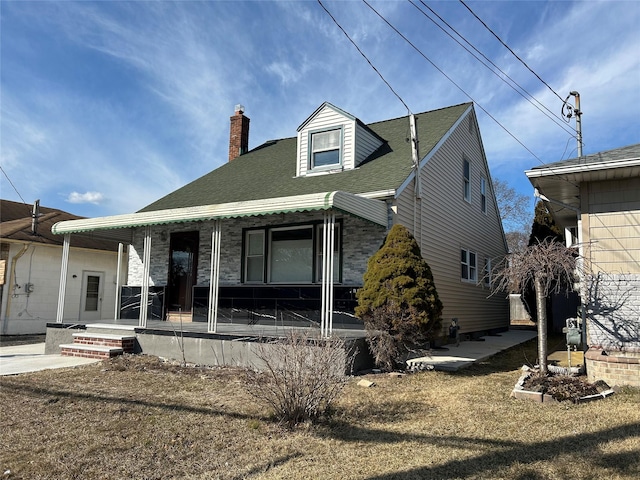 view of front of house featuring a shingled roof and a chimney