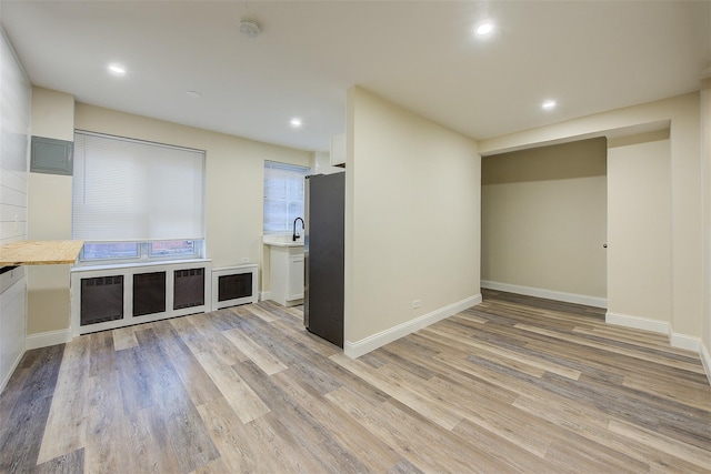 unfurnished living room with light hardwood / wood-style floors and sink