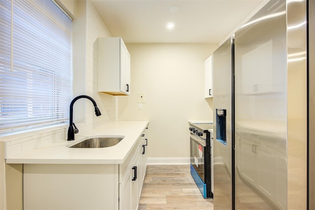 kitchen with light wood-type flooring, sink, white cabinetry, and electric stove