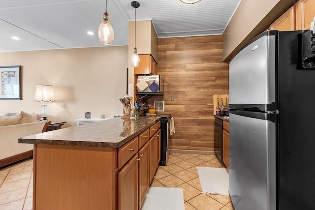 kitchen with light tile patterned floors, decorative light fixtures, black appliances, and wood walls