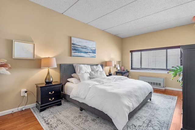 bedroom featuring hardwood / wood-style floors and radiator heating unit