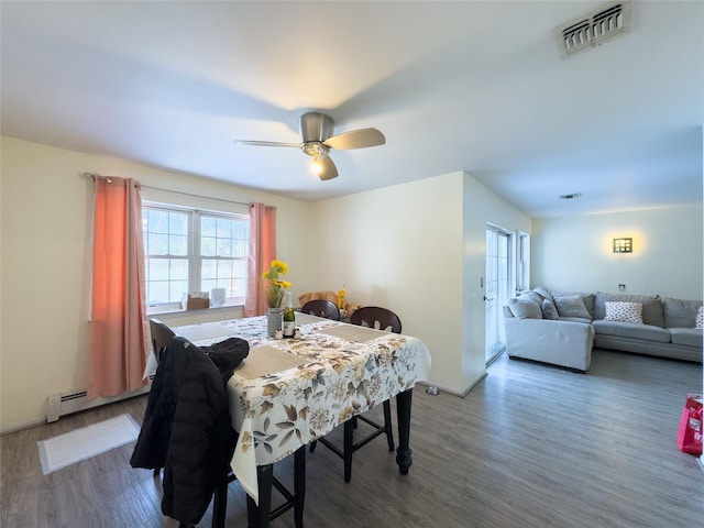 dining space featuring ceiling fan, wood-type flooring, and a baseboard radiator