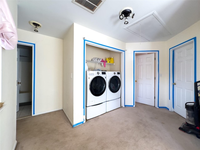 laundry area featuring washing machine and clothes dryer and light colored carpet