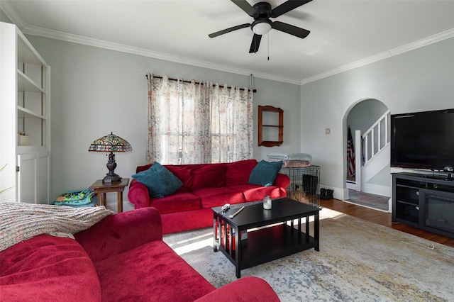 living room with wood-type flooring, ceiling fan, and crown molding