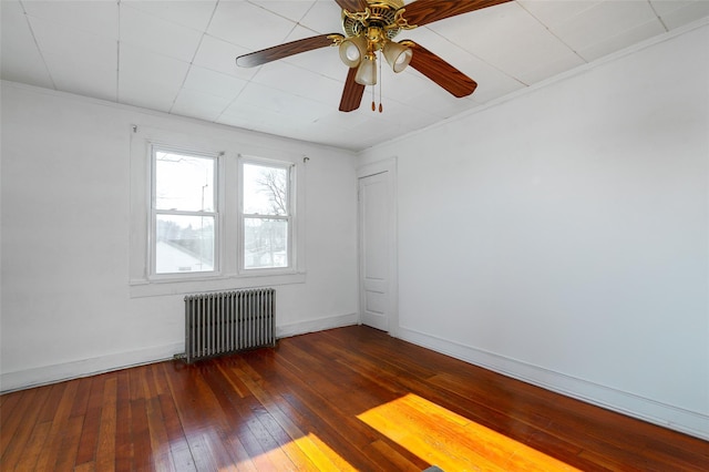 empty room with ceiling fan, ornamental molding, dark wood-type flooring, and radiator