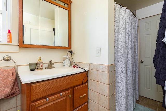 bathroom featuring tile patterned flooring, a shower with curtain, vanity, and tile walls