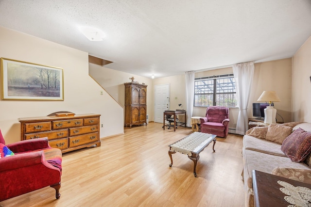 living room featuring light hardwood / wood-style floors and a textured ceiling