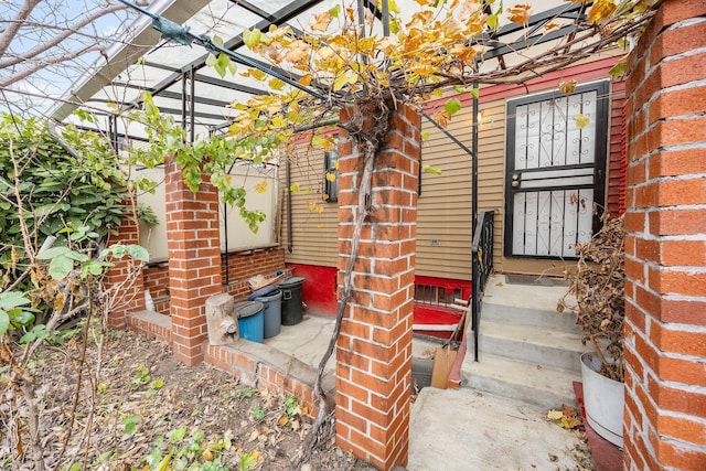 view of exterior entry with a pergola