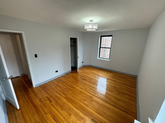 unfurnished bedroom with hardwood / wood-style flooring and a closet