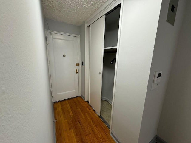 hallway featuring hardwood / wood-style floors and a textured ceiling