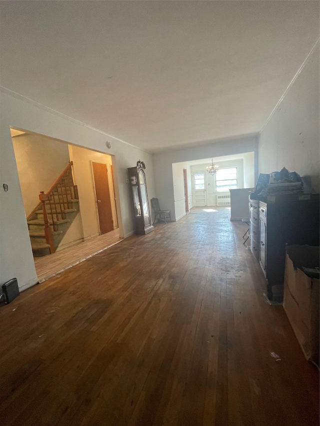 living area featuring wood-type flooring, a notable chandelier, and stairs