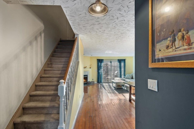 202 Essex Ct, Brewster, NY 10509 - stairway with hardwood / wood-style flooring and a textured ceiling