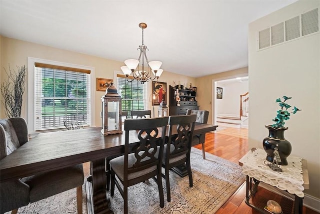 dining area featuring an inviting chandelier and hardwood / wood-style flooring