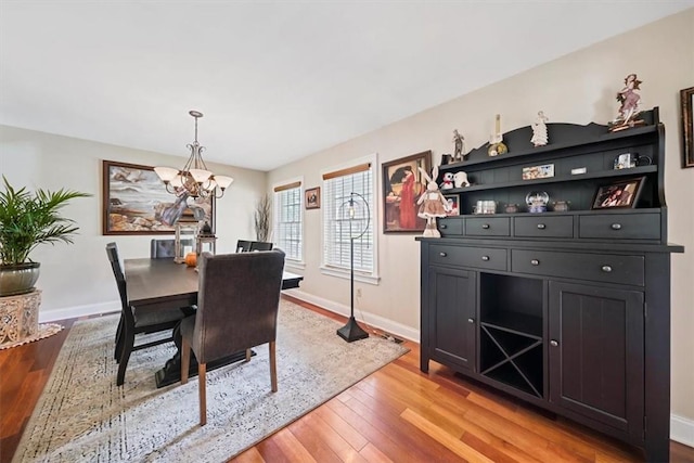 dining space with a notable chandelier and light hardwood / wood-style flooring