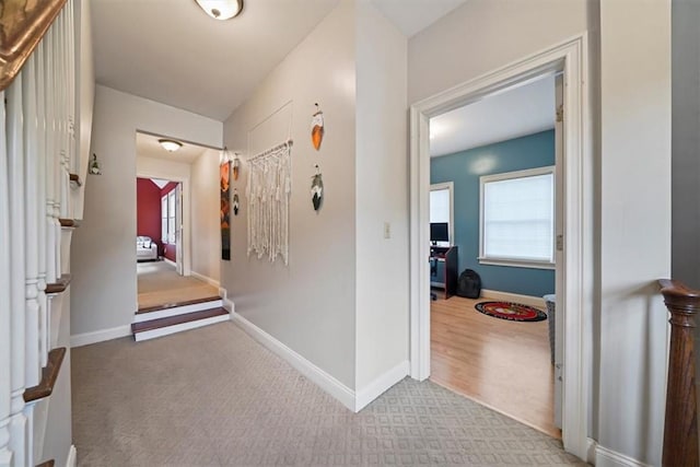 hallway featuring light colored carpet and a healthy amount of sunlight