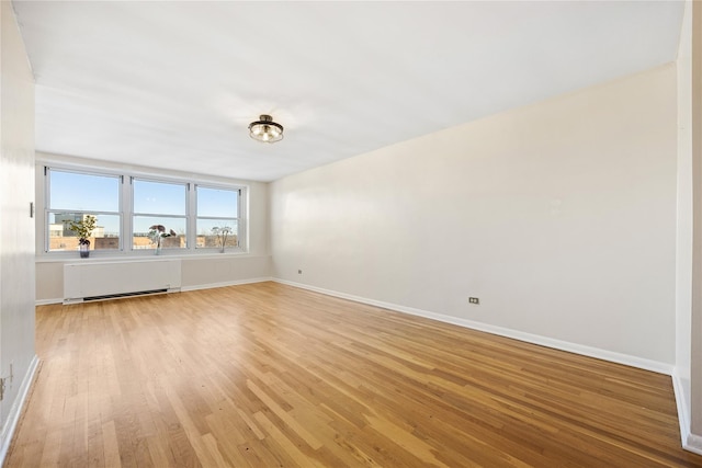 unfurnished room featuring light hardwood / wood-style flooring and radiator