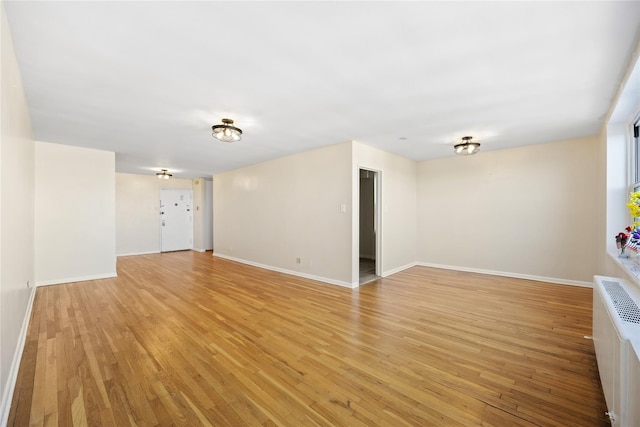 unfurnished room featuring light wood-type flooring and radiator