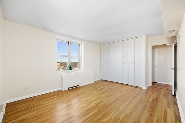 unfurnished bedroom with light hardwood / wood-style floors and a closet