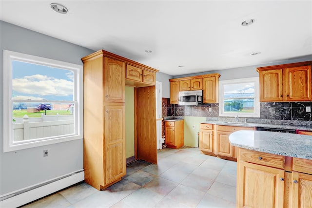 kitchen with decorative backsplash, sink, light stone counters, and a baseboard heating unit