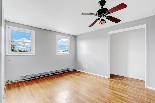 unfurnished bedroom with ceiling fan, light wood-type flooring, and a baseboard radiator