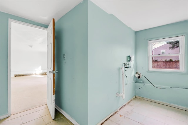 clothes washing area featuring light tile patterned floors