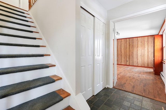 stairway featuring wooden walls