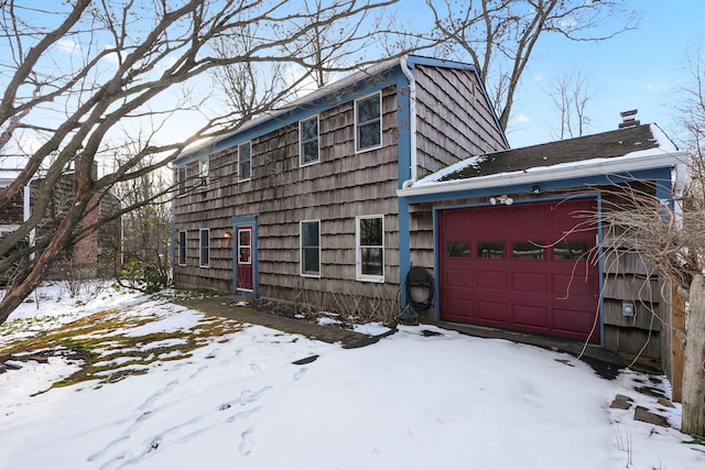 view of snowy exterior featuring a garage