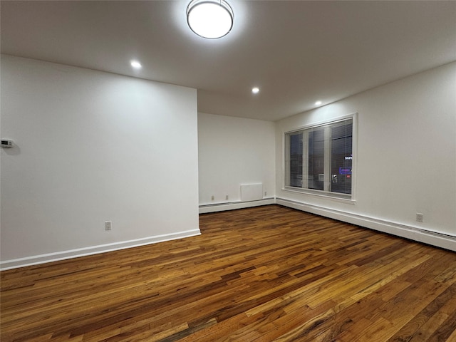 spare room featuring dark hardwood / wood-style floors and a baseboard radiator