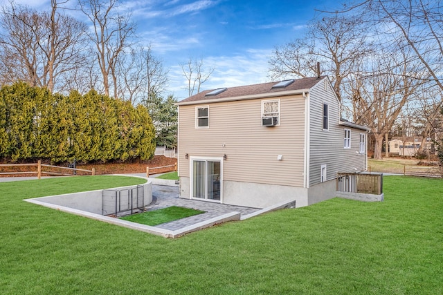 rear view of house featuring cooling unit and a yard