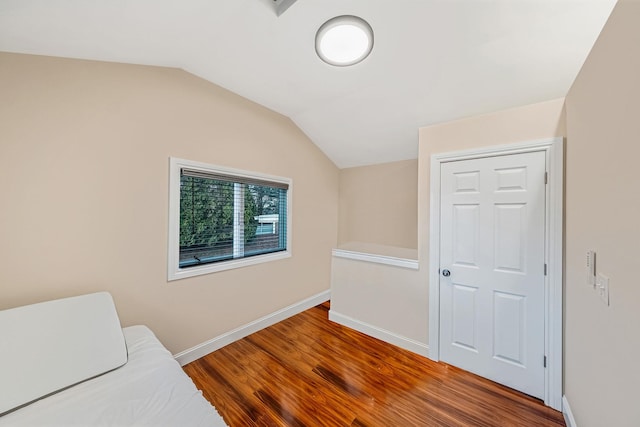 sitting room featuring wood-type flooring and vaulted ceiling