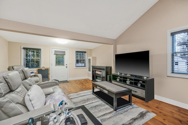 living room featuring hardwood / wood-style floors, a healthy amount of sunlight, and vaulted ceiling