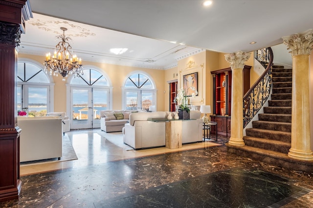 living room featuring french doors, an inviting chandelier, ornate columns, and ornamental molding