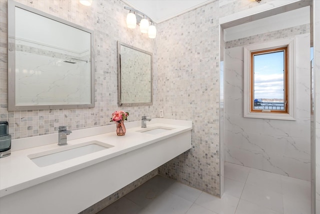 bathroom with tile patterned floors, a shower, vanity, and tile walls