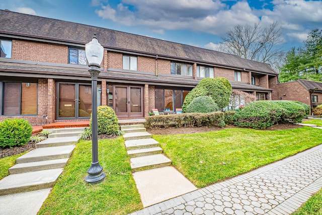 townhome / multi-family property with a front yard and french doors