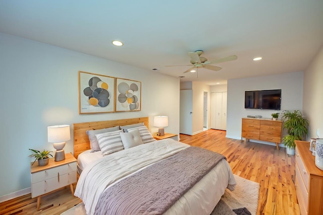 bedroom featuring ceiling fan, a closet, and light hardwood / wood-style flooring