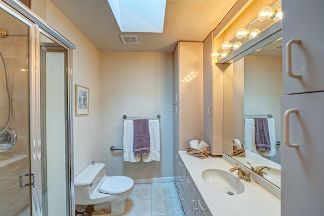 bathroom featuring a skylight, walk in shower, tile patterned floors, toilet, and vanity