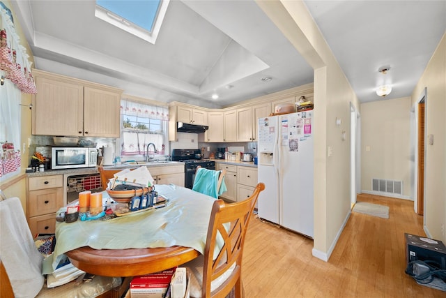 kitchen featuring sink, white appliances, light hardwood / wood-style flooring, and light brown cabinets