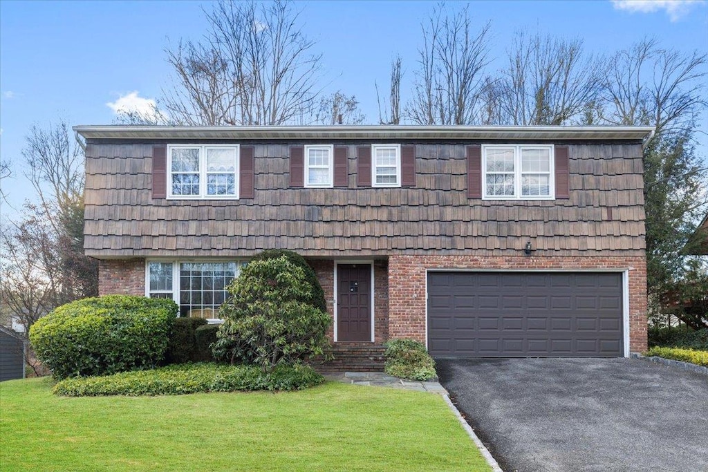 view of front of property with a garage and a front lawn