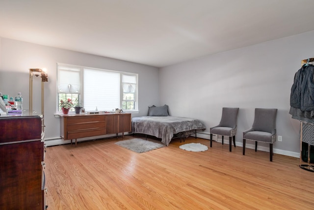 bedroom with light wood-type flooring and baseboard heating