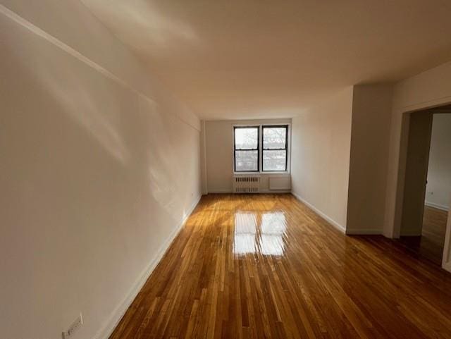 spare room with radiator and hardwood / wood-style floors