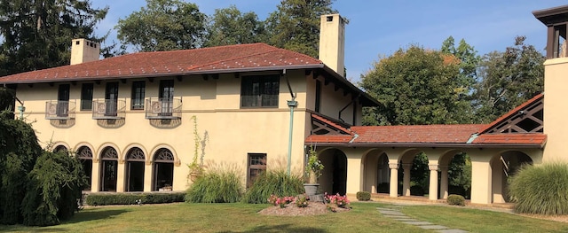 back of house featuring a yard and a balcony