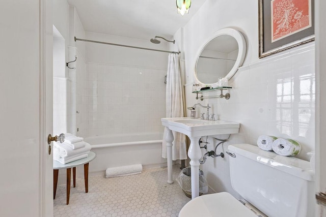 bathroom with toilet, tile patterned floors, tile walls, and shower / tub combo with curtain