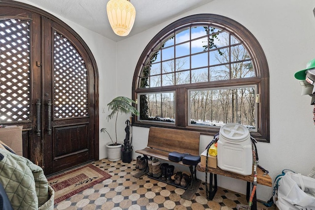 foyer entrance with light floors and arched walkways