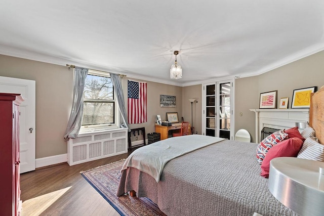 bedroom with a fireplace, baseboards, dark wood-type flooring, and ornamental molding