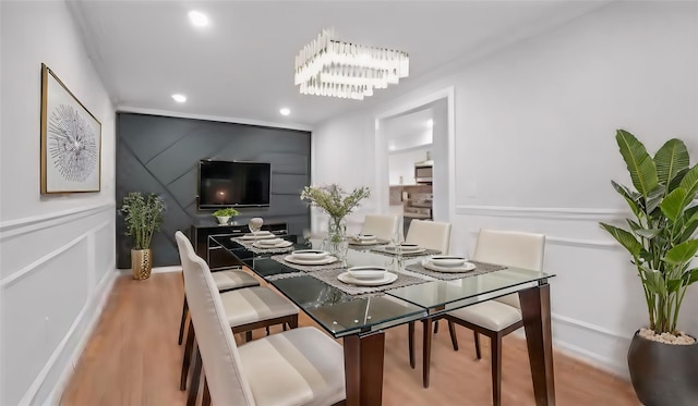 dining room with light hardwood / wood-style floors and a notable chandelier