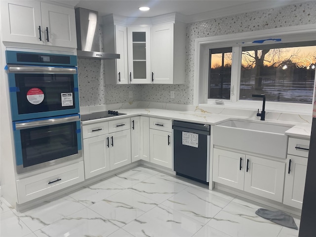 kitchen with black appliances, white cabinets, sink, wall chimney exhaust hood, and light stone counters