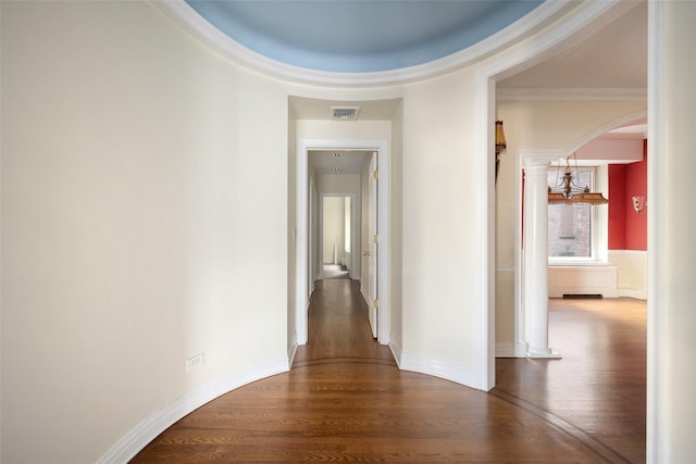 hall with hardwood / wood-style flooring, decorative columns, and crown molding