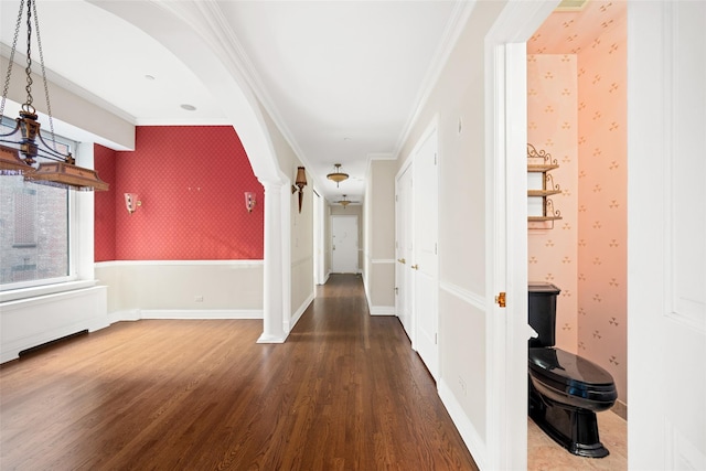 hall featuring ornate columns, crown molding, and hardwood / wood-style flooring